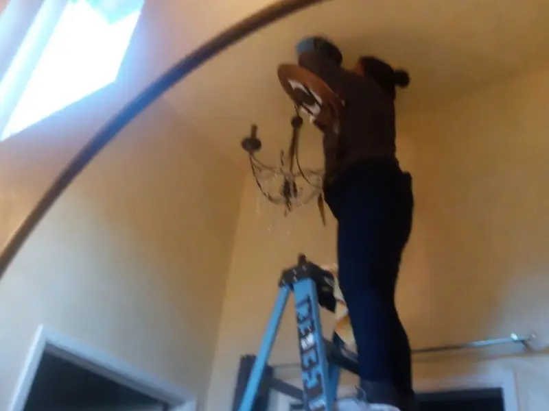 Electrician installing a chandelier in a Dell Rapids residence